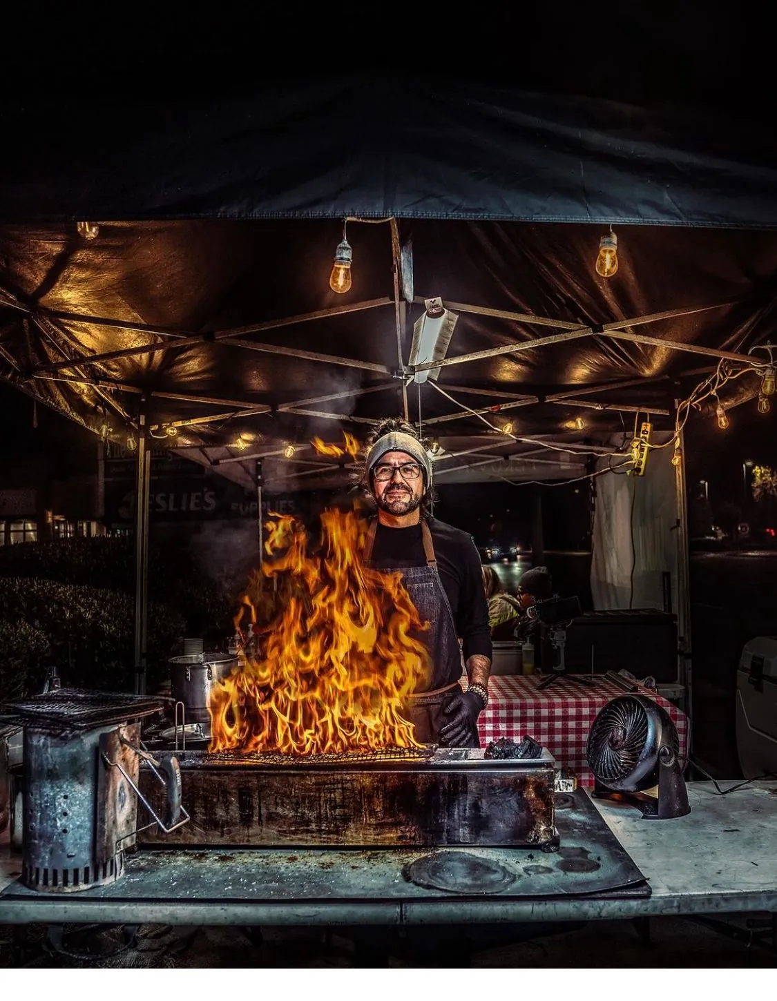 Chef Pablo De la Cruz at the live-fire robata grill at night